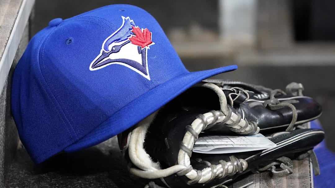Apr 16, 2025; Toronto, Ontario, CAN; A Toronto Blue Jays hat and glove in the dugout during a game against the Atlanta Braves at Rogers Centre. 