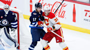 Oct 2, 2024; Winnipeg, Manitoba, CAN;  Winnipeg Jets defenseman Elias Salomonsson (57) jostles for position with Calgary Flames forward Anthony Mantha (39) during the third period at Canada Life Centre. Mandatory Credit: Terrence Lee-Imagn Images