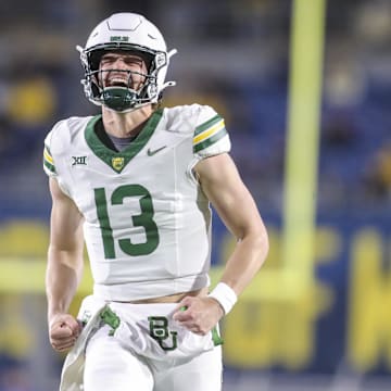 Nov 16, 2024; Morgantown, West Virginia, USA; Baylor Bears quarterback Sawyer Robertson (13) celebrates after a touchdown during the second quarter against the West Virginia Mountaineers at Mountaineer Field at Milan Puskar Stadium. Mandatory Credit: Ben Queen-Imagn Images