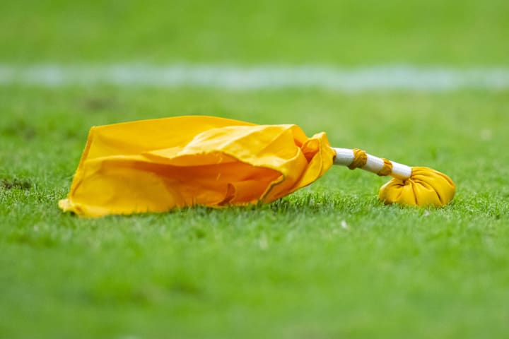 Detailed view of a yellow penalty flag on the field during the Arizona Cardinals training camp practice. 