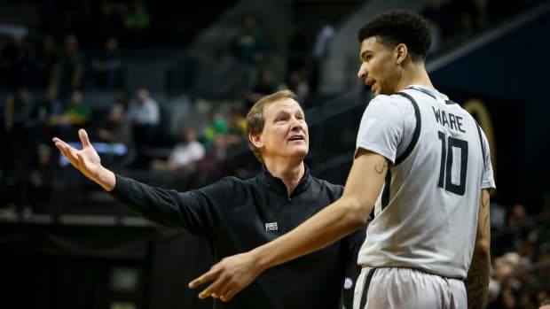 Oregon head coach Dana Altman talks to Oregon center Kel'el Ware as he returns to the bench