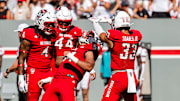 Oct 4, 2025; Raleigh, North Carolina, USA;  NC State Wolfpack defensive end Sabastian Harsh (54) and linebacker Jr. Kenny Soares (33) celebrate a tackle during the first half of the game against Campbell Fighting Camels at Carter-Finley Stadium. Mandatory Credit: Jaylynn Nash-Imagn Images