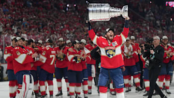 Jun 17, 2025; Sunrise, Florida, USA; Florida Panthers left wing Matthew Tkachuk (19) hoist the Stanley Cup after game six of the 2025 Stanley Cup Final against the Edmonton Oilers at Amerant Bank Arena. Mandatory Credit: Jim Rassol-Imagn Images