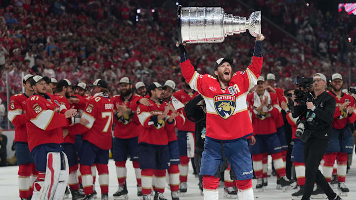 Jun 17, 2025; Sunrise, Florida, USA; Florida Panthers left wing Matthew Tkachuk (19) hoist the Stanley Cup after game six of the 2025 Stanley Cup Final against the Edmonton Oilers at Amerant Bank Arena. Mandatory Credit: Jim Rassol-Imagn Images