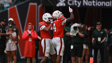 Sep 13, 2025; Miami Gardens, Florida, USA; Miami Hurricanes running back Mark Fletcher Jr. (4) celebrates with wide receiver CJ Daniels (7) after scoring a touchdown against the South Florida Bulls during the second quarter at Hard Rock Stadium. Mandatory Credit: Sam Navarro-Imagn Images