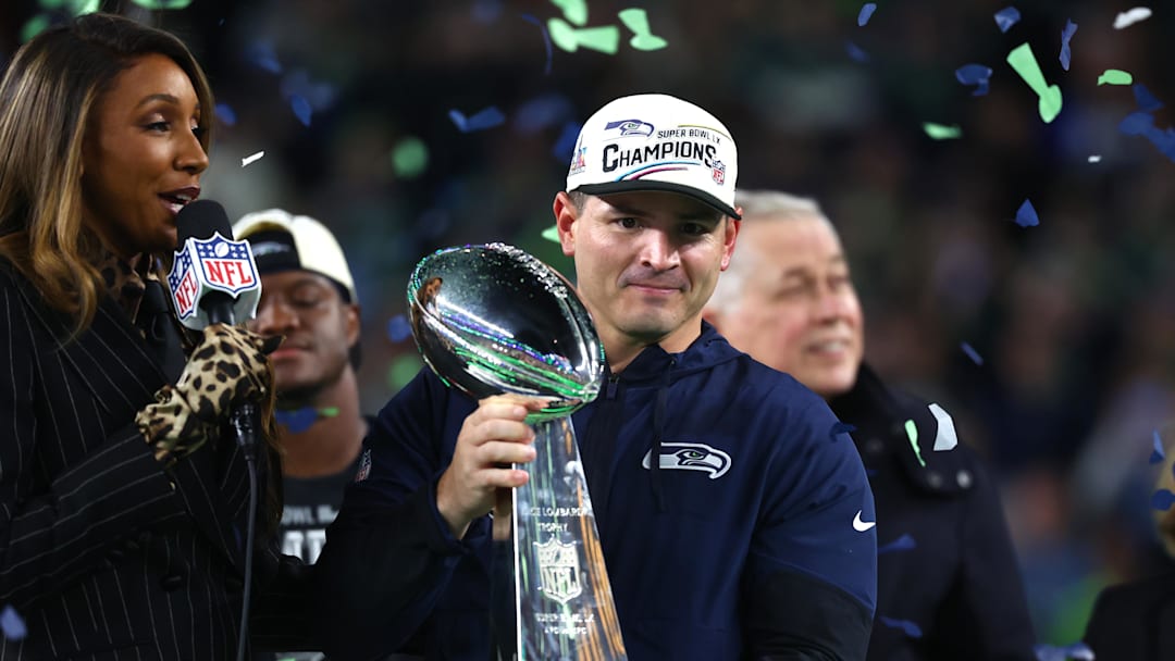 Feb 8, 2026; Santa Clara, CA, USA; Seattle Seahawks head coach Mike MacDonald celebrates with the Vince Lombardi trophy on the podium after defeating the New England Patriots in Super Bowl LX at Levi's Stadium. Mandatory Credit: Mark J. Rebilas-Imagn Images