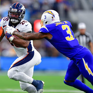 Dec 10, 2023; Inglewood, California, USA; Denver Broncos running back Samaje Perine (25) runs the ball against Los Angeles Chargers safety Derwin James Jr. (3) during the second half at SoFi Stadium. Mandatory Credit: Gary A. Vasquez-Imagn Images