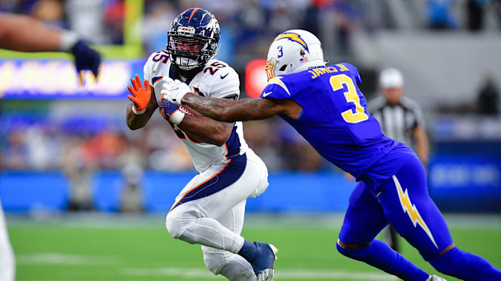 Dec 10, 2023; Inglewood, California, USA; Denver Broncos running back Samaje Perine (25) runs the ball against Los Angeles Chargers safety Derwin James Jr. (3) during the second half at SoFi Stadium. Mandatory Credit: Gary A. Vasquez-Imagn Images