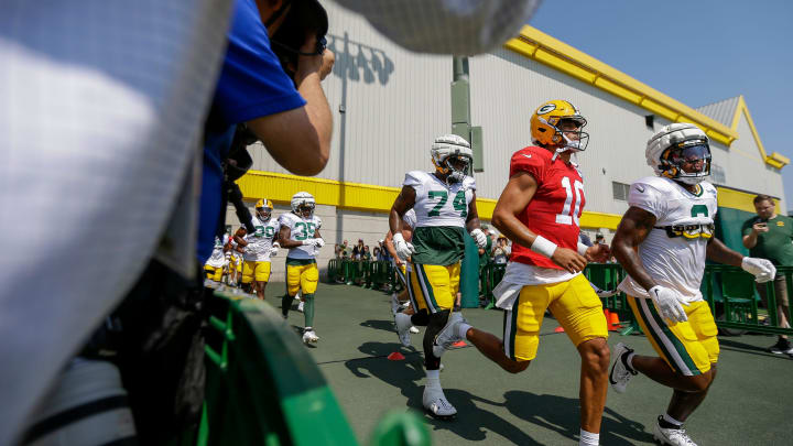 Green Bay Packers quarterback Jordan Love (10) runs onto the practice field for his first practice of training camp on Saturday.