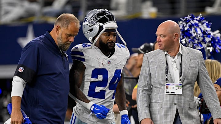 Dallas Cowboys running back Miles Sanders walks off the field with team staff against the Green Bay Packers Dallas Cowboys running back Miles Sanders walks off the field with team staff against the Green Bay Packers