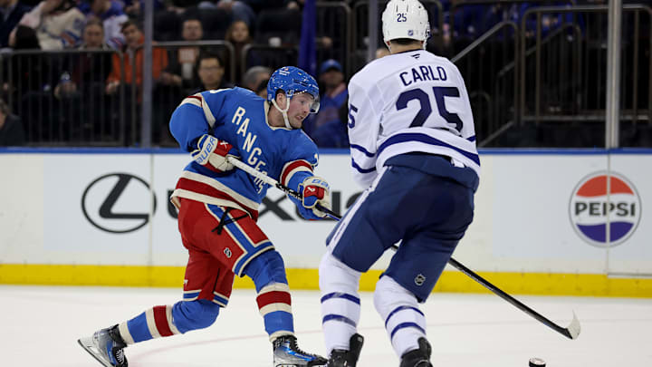 Mar 5, 2026; New York, New York, USA; New York Rangers left wing Alexis Lafreniere (13) takes a shot against Toronto Maple Leafs defenseman Brandon Carlo (25) during the second period at Madison Square Garden. Mandatory Credit: Brad Penner-Imagn Images