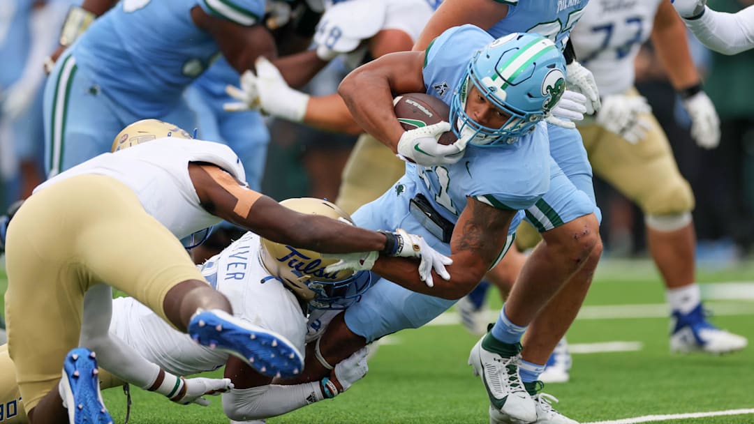 Nov 11, 2023; New Orleans, Louisiana, USA; Tulane Green Wave running back Makhi Hughes (21) struggles for yardage near the goal line as he is tackled by Tulsa Golden Hurricane safety Jaise Oliver (25) in first quarter action at Yulman Stadium.