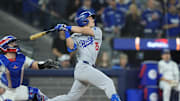 Nov 1, 2025; Toronto, Ontario, CAN; Los Angeles Dodgers second baseman Tommy Edman (25) hits an RBI sacrifice fly against the Toronto Blue Jays in the sixth inning during game seven of the 2025 MLB World Series at Rogers Centre. Mandatory Credit: John E. Sokolowski-Imagn Images