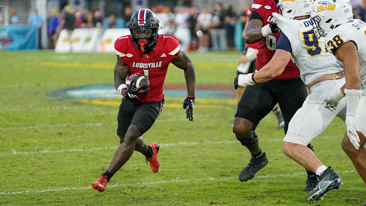 Dec 23, 2025; Boca Raton, FL, USA; Louisville Cardinals running back Isaac Brown (1) rushes for a first down during the fourth quarter of the Boca Raton Bowl at Flagler CU Stadium. Mandatory Credit: Jeff Romance-Imagn Images