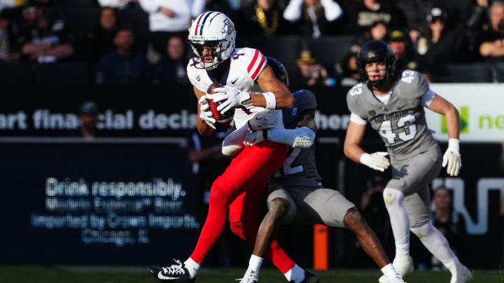 Nov 11, 2023; Boulder, Colorado, USA; Colorado Buffaloes cornerback Travis Hunter (12) tackles Arizona Wildcats wide receiver Tetairoa McMillan (4) in the second half at Folsom Field. 