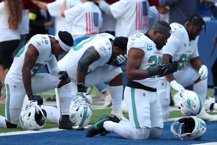 Miami Dolphins linebacker Jordyn Brooks prays with teammates before a game against the Indianapolis Colts.