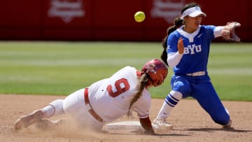 Oklahoma catcher Kinzie Hansen (9) slides to second as the ball goes past BYU shortstop Ailana Agbayani (50) in the fifth inning of a college softball game between the University of Oklahoma Sooners (OU) and BYU at Love's Field in Norman, Okla., Saturday, April 13, 2024. Oklahoma won 7-3.