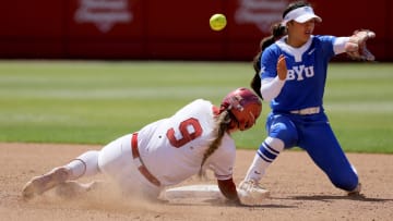 Oklahoma catcher Kinzie Hansen (9) slides to second as the ball goes past BYU shortstop Ailana Agbayani (50) in the fifth inning of a college softball game between the University of Oklahoma Sooners (OU) and BYU at Love's Field in Norman, Okla., Saturday, April 13, 2024. 