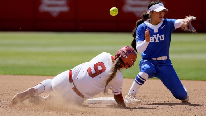 Oklahoma catcher Kinzie Hansen (9) slides to second as the ball goes past BYU shortstop Ailana Agbayani (50) in the fifth inning of a college softball game between the University of Oklahoma Sooners (OU) and BYU at Love's Field in Norman, Okla., Saturday, April 13, 2024. 