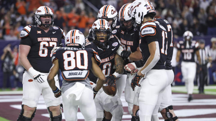 Dec 27, 2023; Houston, TX, USA; Oklahoma State Cowboys running back Ollie Gordon II (0) celebrates with teammates after a touchdown during the second quarter against the Texas A&M Aggies at NRG Stadium. Mandatory Credit: Troy Taormina-USA TODAY Sports