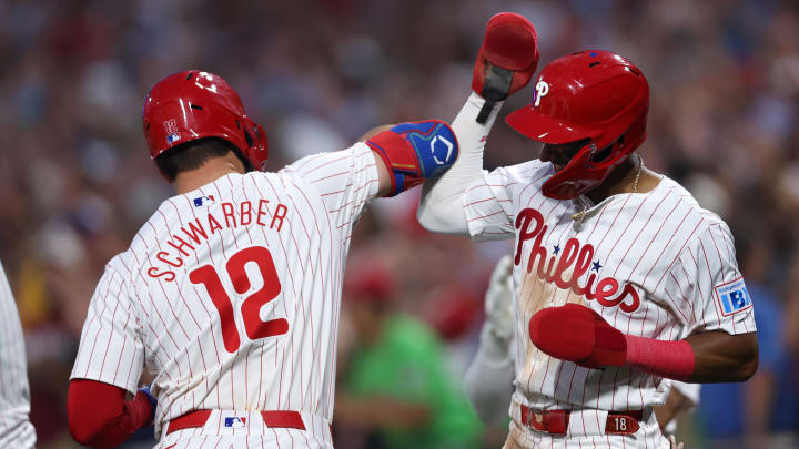 Aug 14, 2024; Philadelphia, Pennsylvania, USA; Philadelphia Phillies designated hitter Kyle Schwarber (12) celebrates with outfielder Johan Rojas (18) after hitting a four RBI grand slam during the fourth inning against the Miami Marlins at Citizens Bank Park. 