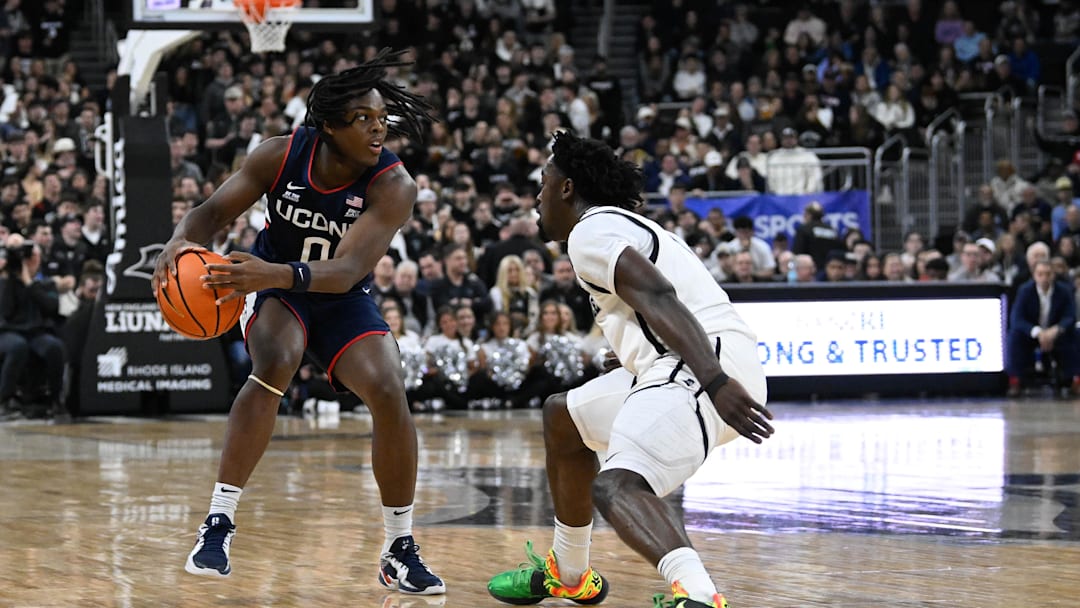 Mar 1, 2025; Providence, Rhode Island, USA; Connecticut Huskies guard Ahmad Nowell (0) passes the ball around Providence Friars guard Bensley Joseph (7) during the first half at Amica Mutual Pavilion. Mandatory Credit: Eric Canha-Imagn Images