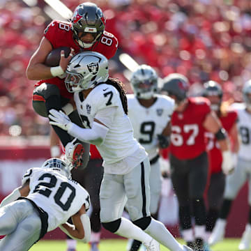 Dec 8, 2024; Tampa, Florida, USA; Tampa Bay Buccaneers tight end Cade Otton (88) is stopped by Las Vegas Raiders safety Tre'von Moehrig (7) in the first quarter at Raymond James Stadium. Mandatory Credit: Nathan Ray Seebeck-Imagn Images