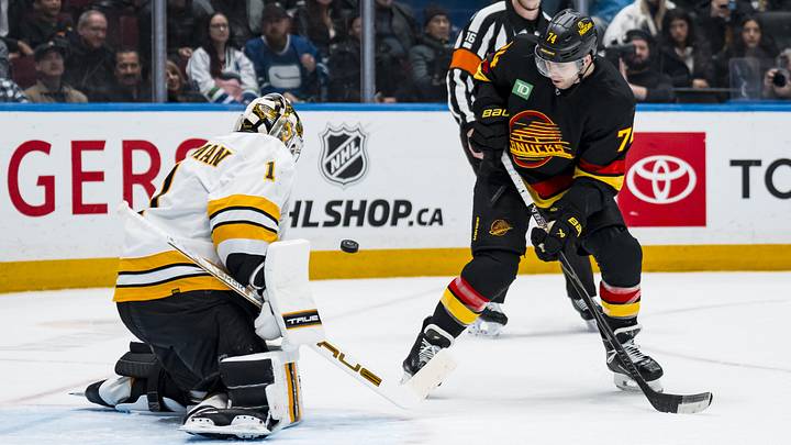 Jan 3, 2026; Vancouver, British Columbia, CAN; Boston Bruins goalie Jeremy Swayman (1) makes a save on Vancouver Canucks forward Jake DeBrusk (74) in the second period at Rogers Arena. Mandatory Credit: Bob Frid-Imagn Images