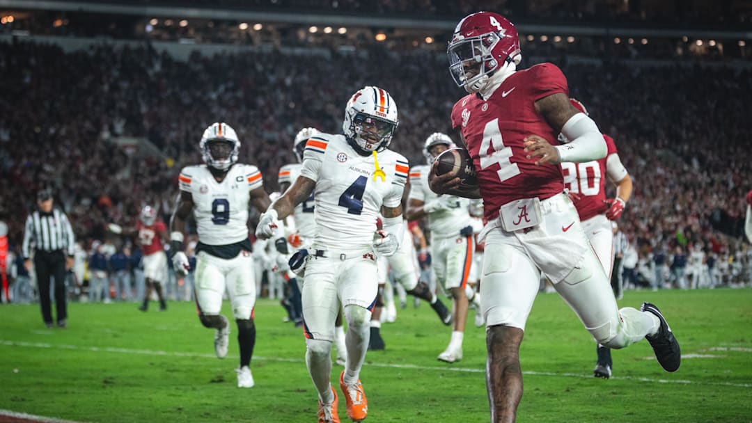 Nov 30, 2024; Tuscaloosa, Alabama, USA; Alabama Crimson Tide quarterback Jalen Milroe (4) scores a touchdown against the Auburn Tigers during the third quarter at Bryant-Denny Stadium. 