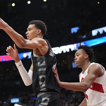 San Antonio Spurs center Victor Wembanyama (1) takes a pass against Toronto Raptors forward Scottie Barnes (4) during the second half at Scotiabank Arena. Mandatory Credit: John E. Sokolowski-Imagn Images
