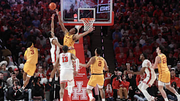 Feb 22, 2025; Houston, Texas, USA; Houston Cougars guard Milos Uzan (7) makes a basket over Iowa State Cyclones center Dishon Jackson (1) in the second half at Fertitta Center. Mandatory Credit: Thomas Shea-Imagn Images