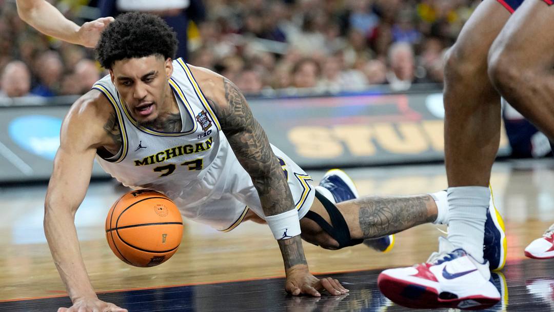 Michigan Wolverines forward Yaxel Lendeborg (23) dives for a loose ball Monday, April 6, 2026, during the NCAA men's basketball tournament national championship game against the UConn Huskies at Lucas Oil Stadium in Indianapolis.