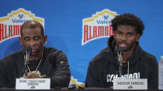 Dec 28, 2024; San Antonio, TX, USA; Colorado Buffaloes head coach Deion Sanders and quarterback Shedeur Sanders (2) talk with the media after the game against the Brigham Young Cougars at Alamodome. Mandatory Credit: Troy Taormina-Imagn Images