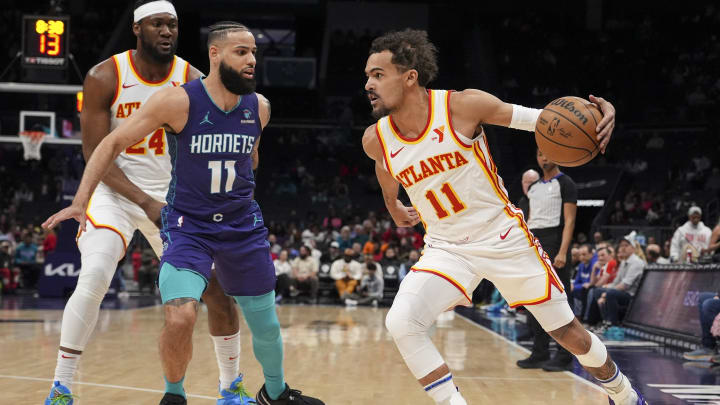 Feb 14, 2024; Charlotte, North Carolina, USA; Atlanta Hawks guard Trae Young (11) dribbles covered by Charlotte Hornets forward Cody Martin (11) during the first quarter at Spectrum Center. Mandatory Credit: Jim Dedmon-USA TODAY Sports