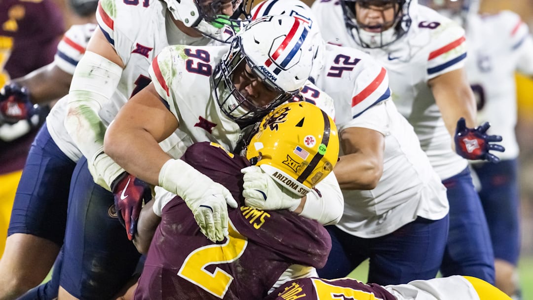 Nov 28, 2025; Tempe, Arizona, USA; Arizona State Sun Devils quarterback Jeff Sims (2) is tackled by Arizona Wildcats defensive lineman Mays Pese (99) in the second half during the 99th Territorial Cup at Mountain America Stadium. Mandatory Credit: Mark J. Rebilas-Imagn Images