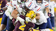 Nov 28, 2025; Tempe, Arizona, USA; Arizona State Sun Devils quarterback Jeff Sims (2) is tackled by Arizona Wildcats defensive lineman Mays Pese (99) in the second half during the 99th Territorial Cup at Mountain America Stadium. Mandatory Credit: Mark J. Rebilas-Imagn Images