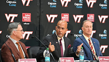 Nov 19, 2025; Blacksburg, VA, USA;  Virginia Tech head coach James Franklin (center) speaks as Virginia Tech President Timothy Sands (left) and Athletic Director Whit Babcock (right) looks on at Cassell Coliseum. Mandatory Credit: Brian Bishop-Imagn Images