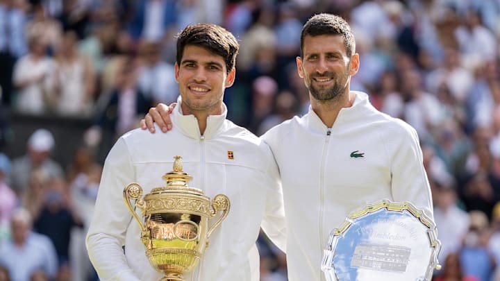 Carlos Alcaraz of Spain and Novak Djokovic of Serbia pose with their trophies.