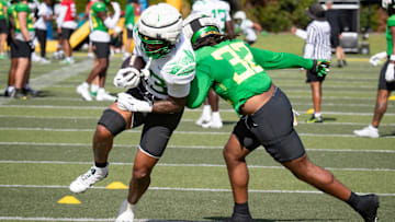 Oregon tight end Roger Saleapaga carries the ball under coverage from linebacker Emar'rion Winston during practice with the Oregon Ducks Tuesday, Aug. 20, 2024 at the Hatfield-Dowlin Complex in Eugene, Ore.