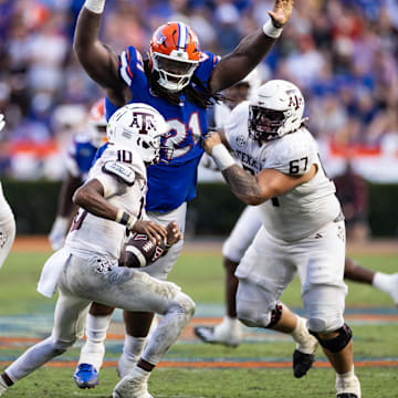 Sep 14, 2024; Gainesville, Florida, USA; Florida Gators defensive lineman Desmond Watson (21) attempts to tackle Texas A&M Aggies quarterback Marcel Reed (10) during the second half at Ben Hill Griffin Stadium. Mandatory Credit: Matt Pendleton-Imagn Images