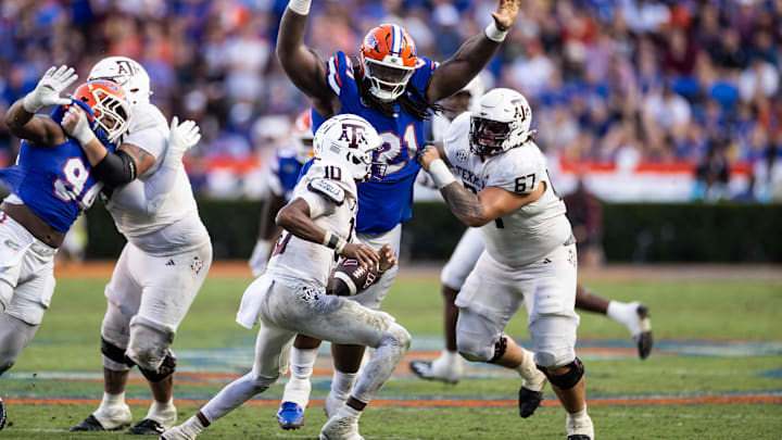 Sep 14, 2024; Gainesville, Florida, USA; Florida Gators defensive lineman Desmond Watson (21) attempts to tackle Texas A&M Aggies quarterback Marcel Reed (10) during the second half at Ben Hill Griffin Stadium. Mandatory Credit: Matt Pendleton-Imagn Images