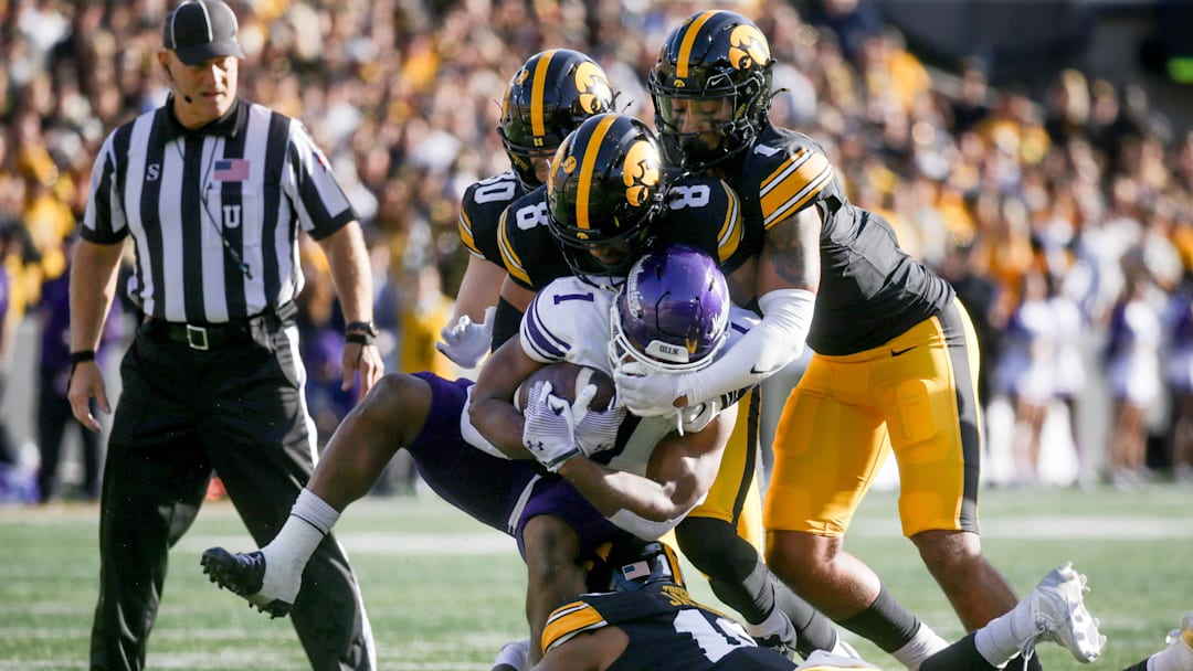 Iowa’s Nick Jackson (10), Deshaun Lee (8), Xavier Nwankpa (1), and Quinn Schulte (30) tackle Northwestern’s Cam Porter (1) Saturday, Oct. 26, 2024 at Kinnick Stadium in Iowa City, Iowa.