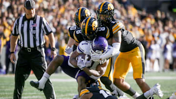 Iowa’s Nick Jackson (10), Deshaun Lee (8), Xavier Nwankpa (1), and Quinn Schulte (30) tackle Northwestern’s Cam Porter (1) Saturday, Oct. 26, 2024 at Kinnick Stadium in Iowa City, Iowa.