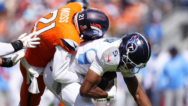 Denver Broncos cornerback Riley Moss (21) tackles Tennessee Titans wide receiver Elic Ayomanor (5) in the first half.