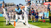 Seattle Seahawks running back Zach Charbonnet (26) scores a touchdown past Tennessee Titans linebacker Jihad Ward (53) during the third quarter at Nissan Stadium in Nashville, Tenn., Sunday, Nov. 23, 2025.