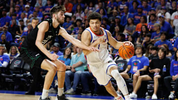 Dec 29, 2024; Gainesville, Florida, USA; Florida Gators guard Walter Clayton Jr. (1) drives to the basket past Stetson Hatters forward Finley Sheridan (21) during the second half at Exactech Arena at the Stephen C. O'Connell Center. Mandatory Credit: Matt Pendleton-Imagn Images