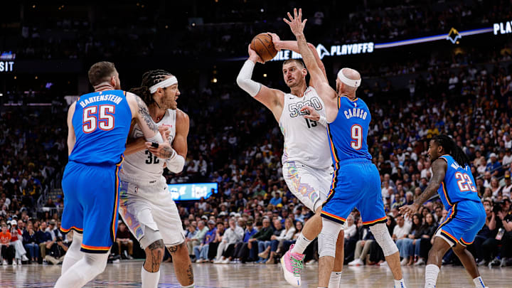 Denver Nuggets center Nikola Jokic (15) looks to pass the ball under pressure from Oklahoma City Thunder guard Alex Caruso (9) as center Isaiah Hartenstein (55) and forward Aaron Gordon (32) battle for position in the third quarter during game six of the second round for the 2025 NBA Playoffs at Ball Arena. 