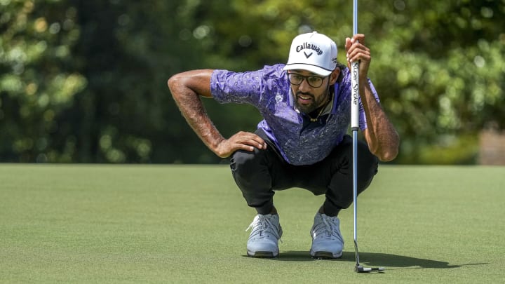 Akshay Bhatia looks over his line on the 14th green during the first round of the Wyndham Championship golf tournament.