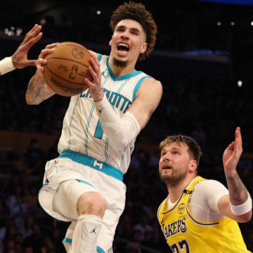 Feb 19, 2025; Los Angeles, California, USA; Charlotte Hornets guard LaMelo Ball (1) shoots against Los Angeles Lakers center Jaxson Hayes (11) and guard Luka Doncic (77) during the fourth quarter at Crypto.com Arena. Mandatory Credit: Jason Parkhurst-Imagn Images