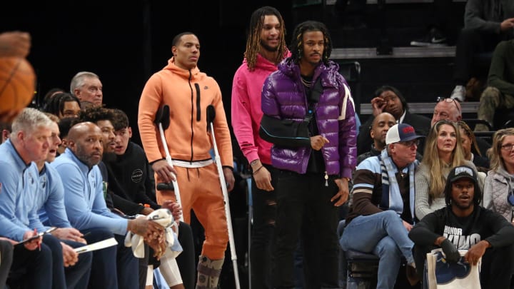 Jan 15, 2024; Memphis, Tennessee, USA; Memphis Grizzlies guard Desmond Bane (22), forward Brandon Clarke (15) and guard Ja Morant (12) watch from the bench during the first half against the Golden State Warriors at FedExForum. 